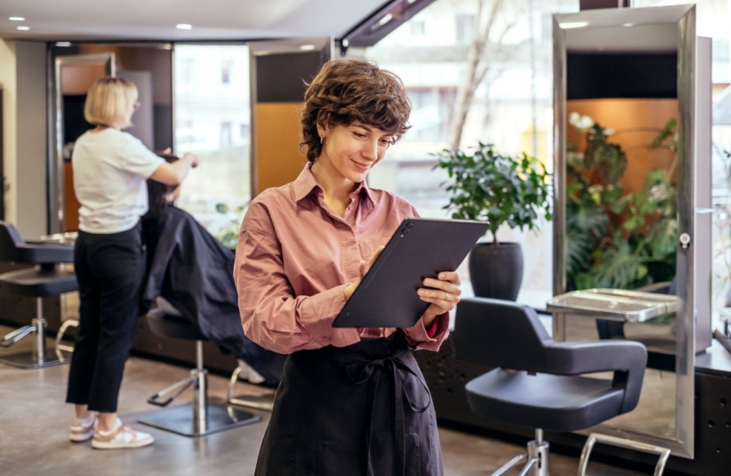 mujer en una oficina haciendo gestiones de pie con una tablet