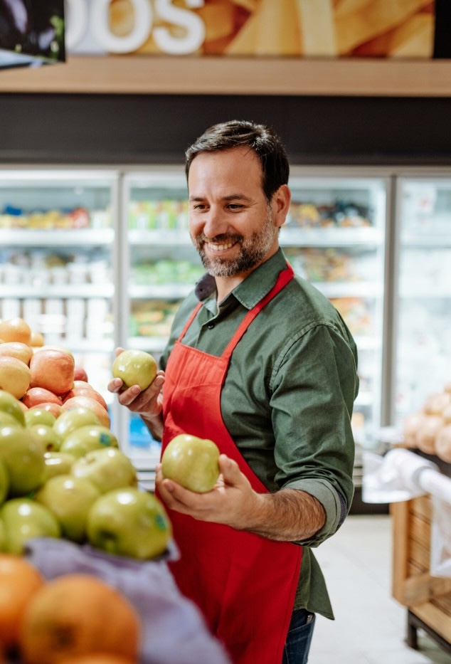 un frutero colocando la fruta