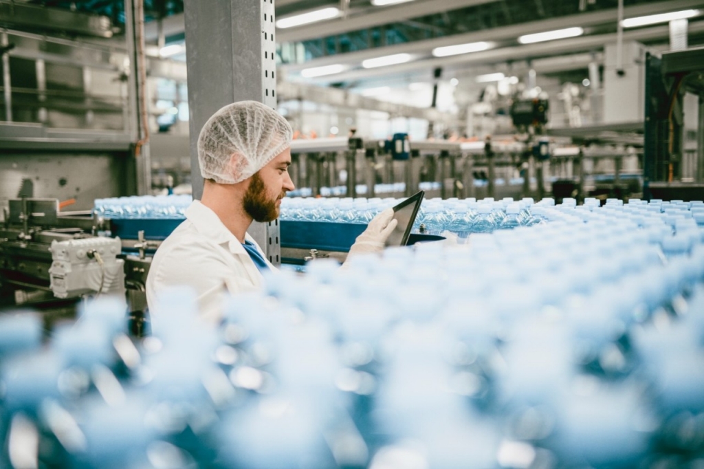 un trabajador en una línea de producción de botellas de agua