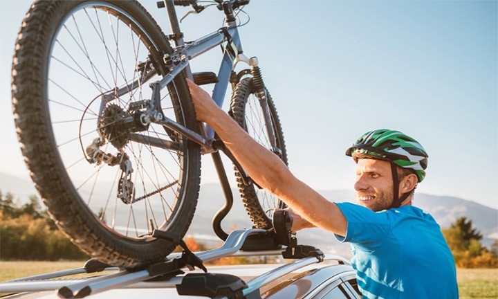 Ciclista colocando la bici en un portabicicletas en el coche