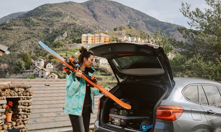 Mujer metiendo los esquís para llevarlos dentro del coche