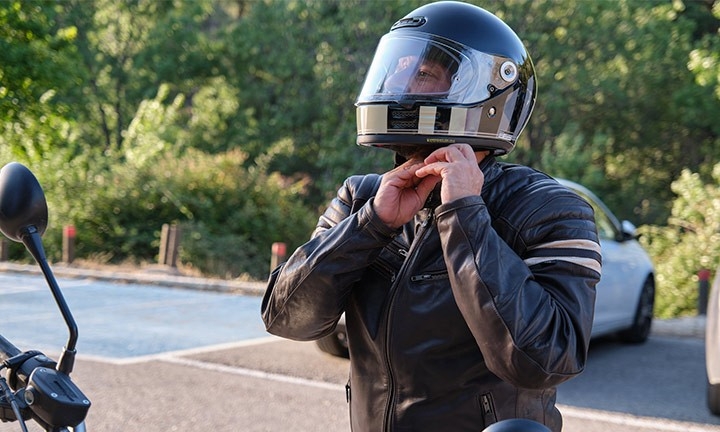 Motorista colocándose el casco de la moto