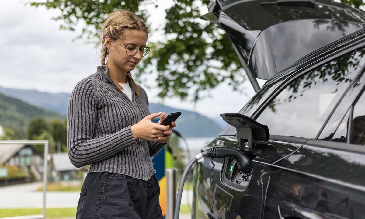 Mujer mirando las coberturas de su seguro coche eléctrico