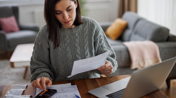 Mujer revisando las dos facturas y cotnratos de luz de su vivienda