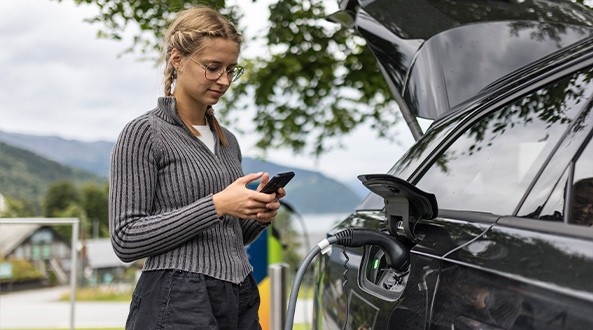 Mujer mirando las coberturas de su seguro coche eléctrico